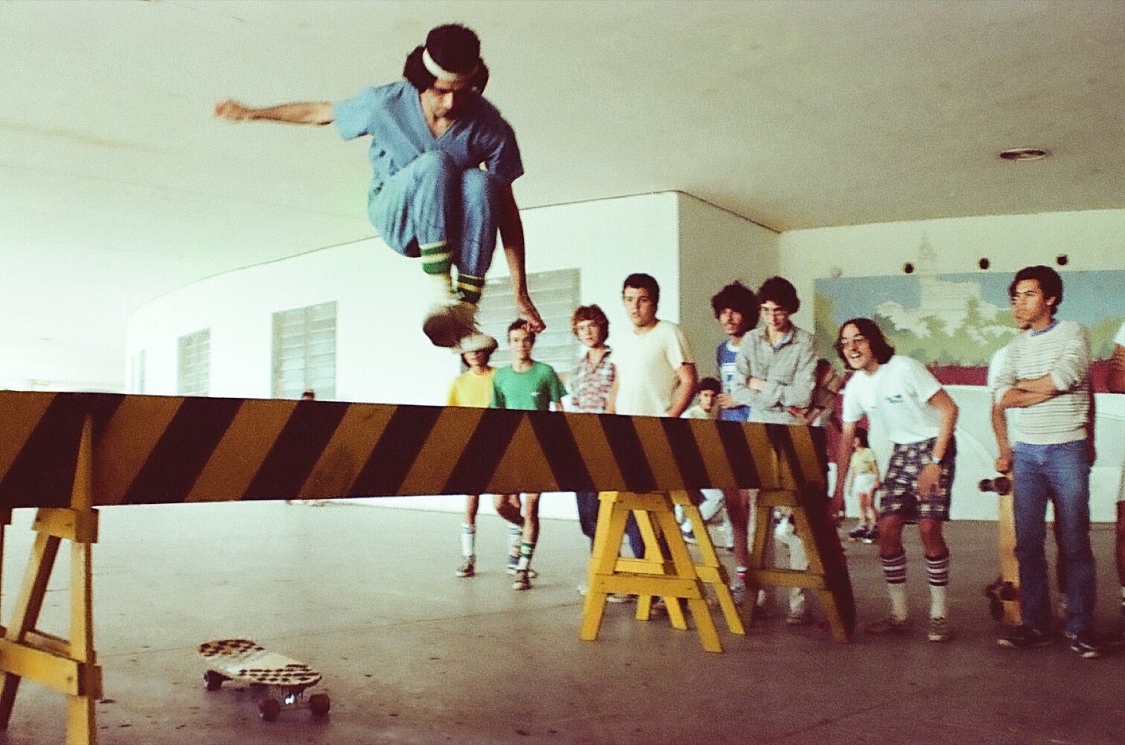 Skatista saltando sobre barricada debaixo da Marquise do Ibirapuera, cercado por amigos, 1982.